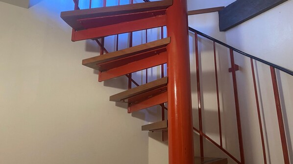 A staircase with wooden steps and a red handrail. - Moonbah Ski Lodge is a freestanding A frame ski lodge (Thredbo)
