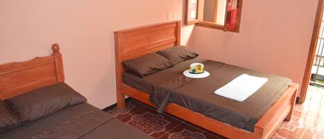 A bedroom with two wooden beds, a mirror, and patterned floor tiles.