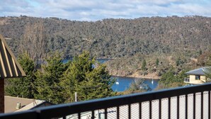 A residential area with a view of a lake and forested hills. - Aspen Court 8 is a comfortable and spacious apartment (Jindabyne)