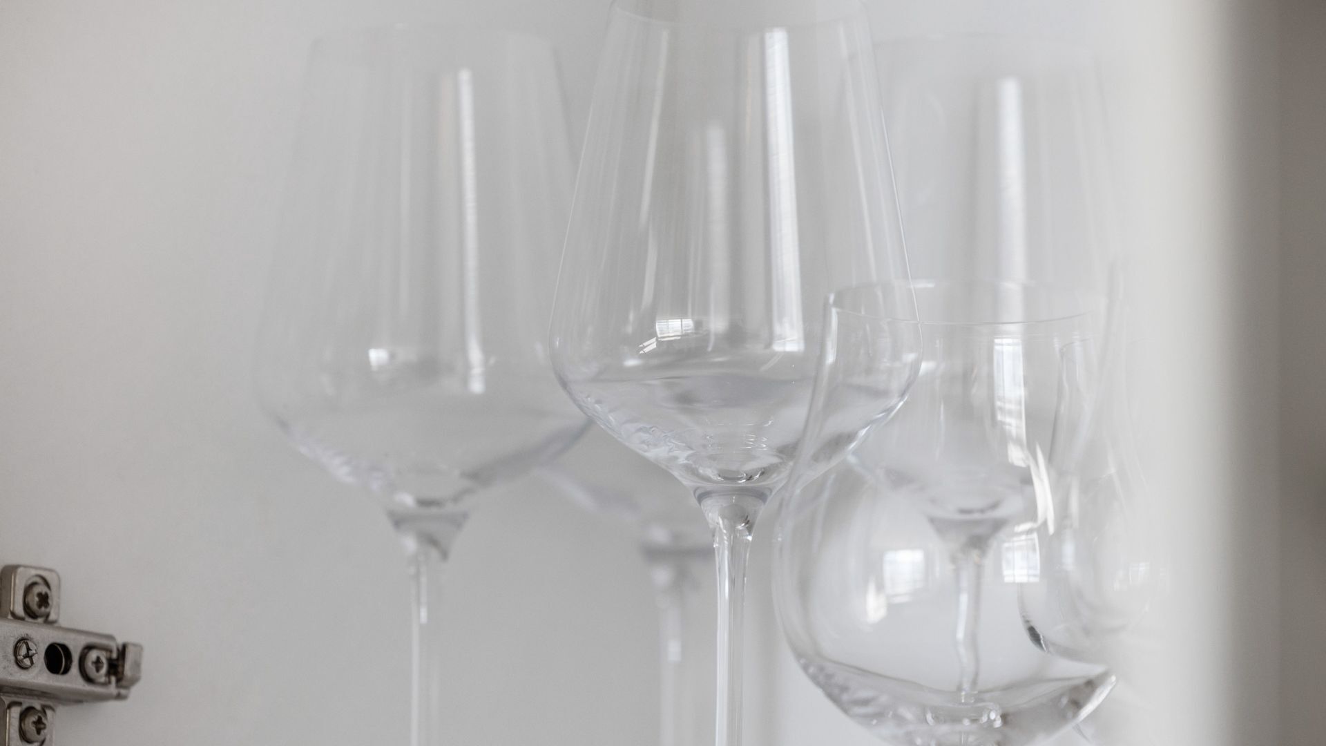 Three empty wine glasses on a white surface.