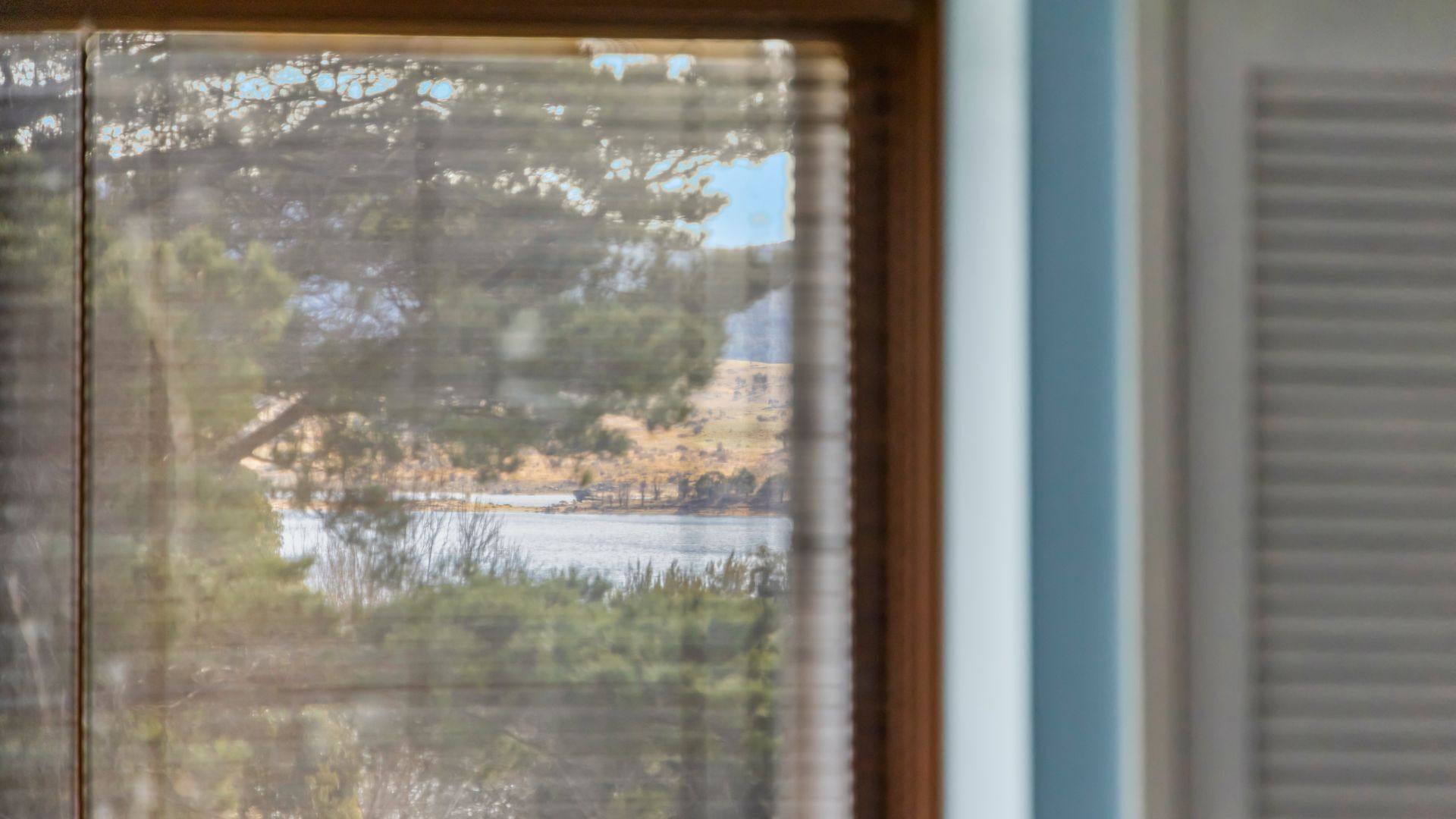 A view through a window with a view of a lake and trees.