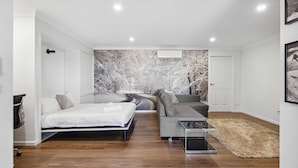 A modern bedroom with a bed, a sofa, and a coffee table.