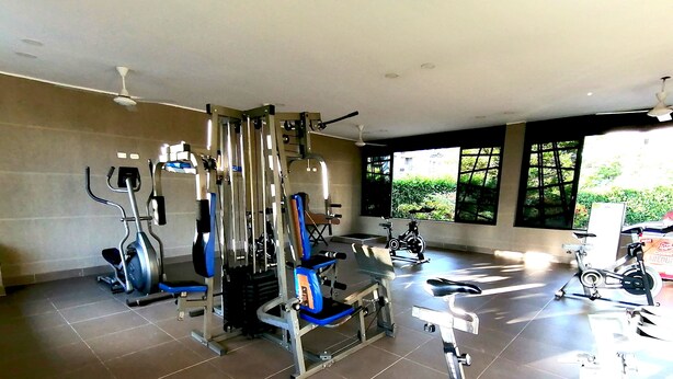A gym with various exercise equipment, including a multi-functional machine, stationary bikes, and a rowing machine. - Confortable Apartamento Vacacional  (Ricaurte)