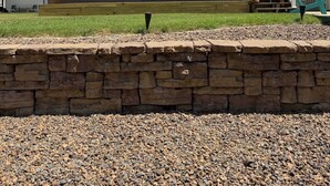 A single-story house with a porch, a stone wall in the foreground, and a clear sky. - Relax with Nature (Coldwater)