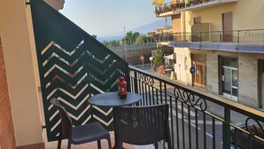 A balcony with a chevron-patterned wall, a round table with two chairs, and a red lantern. - The White Lodge (Sorrento)
