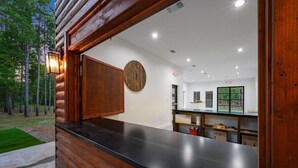 L’intérieur d’une cabane en rondins, avec un revêtement extérieur en bois, un comptoir noir et une horloge ronde en bois accrochée au mur.