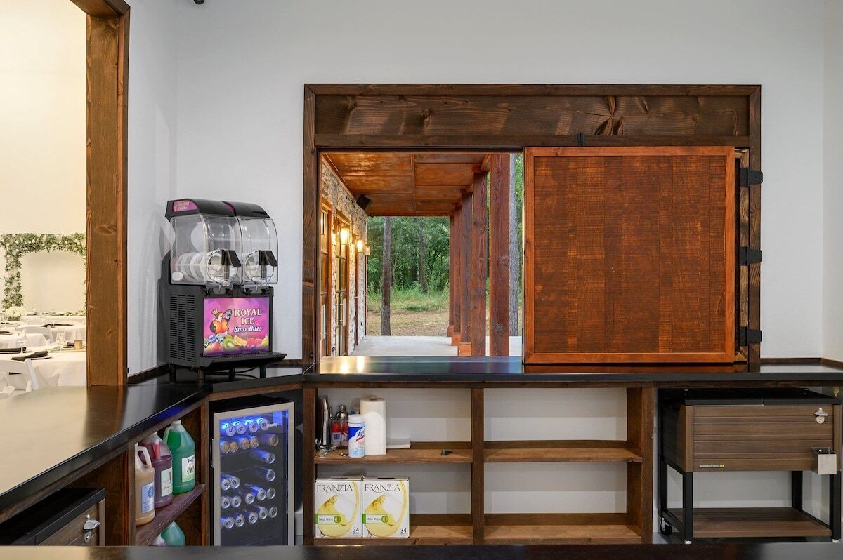 Un espace bar équipé d’un réfrigérateur, d’un distributeur de boissons et d’un meuble en bois.