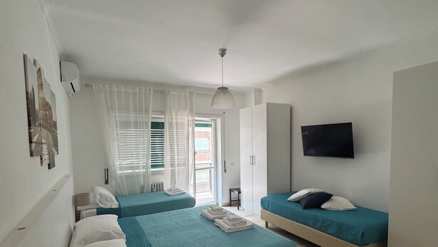 Une chambre d’hôtel avec deux lits, une télévision, une petite table et une chaise.