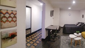 Ein kompakter Wohnraum mit Bett, Esstisch, einer kleinen Couch und Schreibtisch.