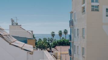 A view of a coastal area with buildings, a clear sky, and the sea in the distance.