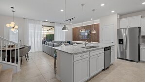 A modern kitchen with a central island, stainless steel appliances, and pendant lighting.