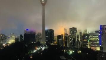 A cityscape at night with a prominent tower and illuminated buildings.