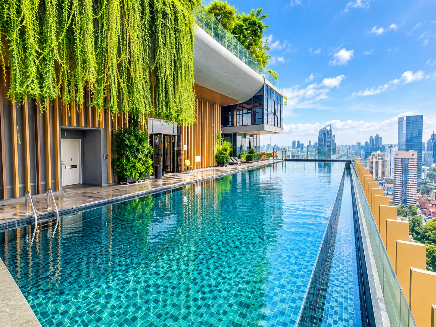 A modern hotel with a rooftop infinity pool overlooking a city skyline.