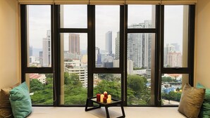 A room with a large window overlooking a cityscape. - Ceylonz Suites by Roomy (Kuala Lumpur)