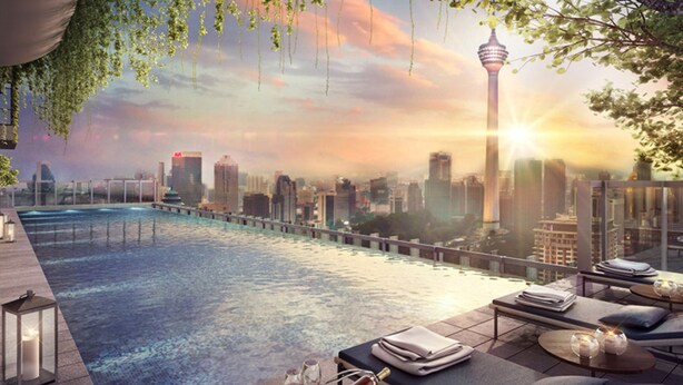 A rooftop pool area with lounge chairs and tables, overlooking a cityscape with a prominent tower. - Ceylonz Suites by Roomy (Kuala Lumpur)