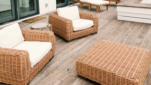A deck with wicker furniture and a barbecue grill. - Stunning Marsh View Pool Retreat on St. Simons Island (St. Simons Island)