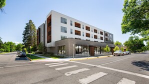 A modern multi-story building with a flat roof and large windows. - Style Points Shelter: Downtown (Bozeman)