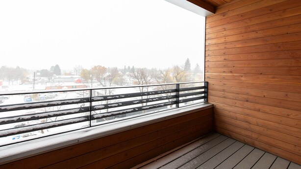 A balcony with wooden railings and a view of a snowy landscape. - Style Points Shelter: Downtown (Bozeman)