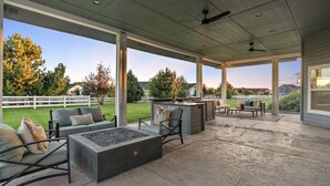 An outdoor patio area with a fire pit, seating, and an outdoor kitchen. - Private Oasis On 2 Acres w/ Indoor Pool & Theater! (Eagle)