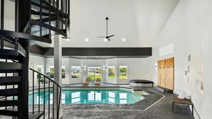 A modern indoor pool area with a clear view of the outdoors, a spa area, and a staircase. - Private Oasis On 2 Acres w/ Indoor Pool & Theater! (Eagle)