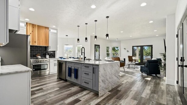 A modern kitchen with a central island, stainless steel appliances, and pendant lighting. - Private Oasis On 2 Acres w/ Indoor Pool & Theater! (Eagle)