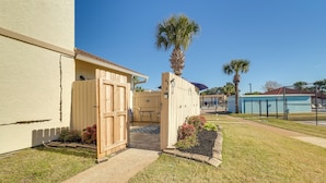 Propiedad residencial con entrada protegida por portón, zona de patio y piscina al fondo.