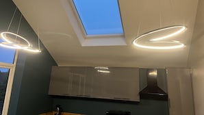 A modern kitchen with a skylight, pendant lights, and stainless steel appliances. - Welcome to Your Stay at The Nest (Bolton)