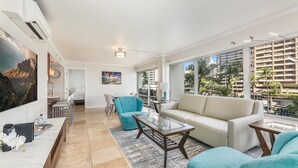 A spacious living area with a sofa, armchairs, a coffee table, and a dining area with chairs and a table. - Splendid 2BD w/ One FREE Parking (Honolulu)