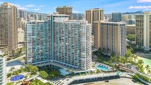 A high-rise hotel with multiple floors, a swimming pool, and a beach area. - Splendid 2BD w/ One FREE Parking (Honolulu)