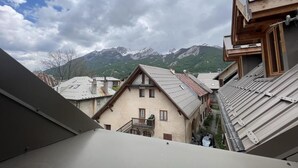 A view of a mountain village with traditional buildings and a prominent mountain range in the background. - 2nd floor, tv, ski locker, 78m², Serre Chevalier (Le Monêtier-les-Bains)