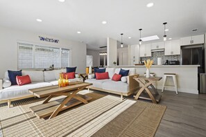 Ein modernes Wohnzimmer mit Sofa, Couchtisch und Essbereich.