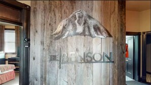 Una reception in legno con una scultura a tema montano e la scritta 'The Benson' incisa.