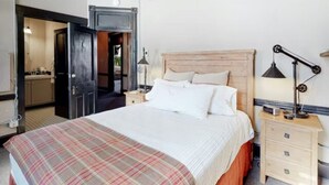 A bedroom with a bed, a nightstand, a lamp, and a wooden headboard. - Benson Lodge Room - 6 (Silverton)