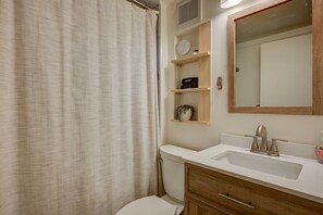 A bathroom with a white sink, wooden vanity, and a mirror above it. There are shelves above the sink with a plant and a small item. - Beautiful Chalet 2 minutes from the Saco River 🚣🔥🌲🗻 (Bartlett)