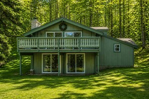 A green wooden house with a balcony, large windows, and a wreath on the front. - Beautiful Chalet 2 minutes from the Saco River 🚣🔥🌲🗻 (Bartlett)