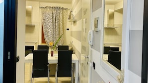 A dining area with a table, chairs, a vase with flowers, and a mirror on the wall. - Vacation home ACCIUGA (Monterosso al Mare)