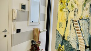 A hallway with a striped wall, a telephone, a mirror, and a painting. - Vacation home ACCIUGA (Monterosso al Mare)