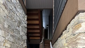 A narrow stone staircase leading to a wooden door.