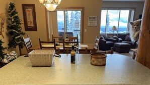 A kitchen with a granite countertop, wooden cabinets, a wicker basket, a glass bottle, and a woven basket.