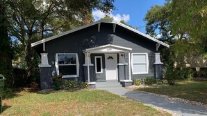 A two-story house with a dark gray exterior, white trim, and a number '1216' on the front door. - Fresh Home near Ybor city  (Tampa)