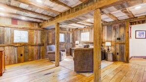 A rustic interior with exposed wooden beams, a fireplace, and a cozy seating area. - The Lodge at Stoneleigh (Round Hill)