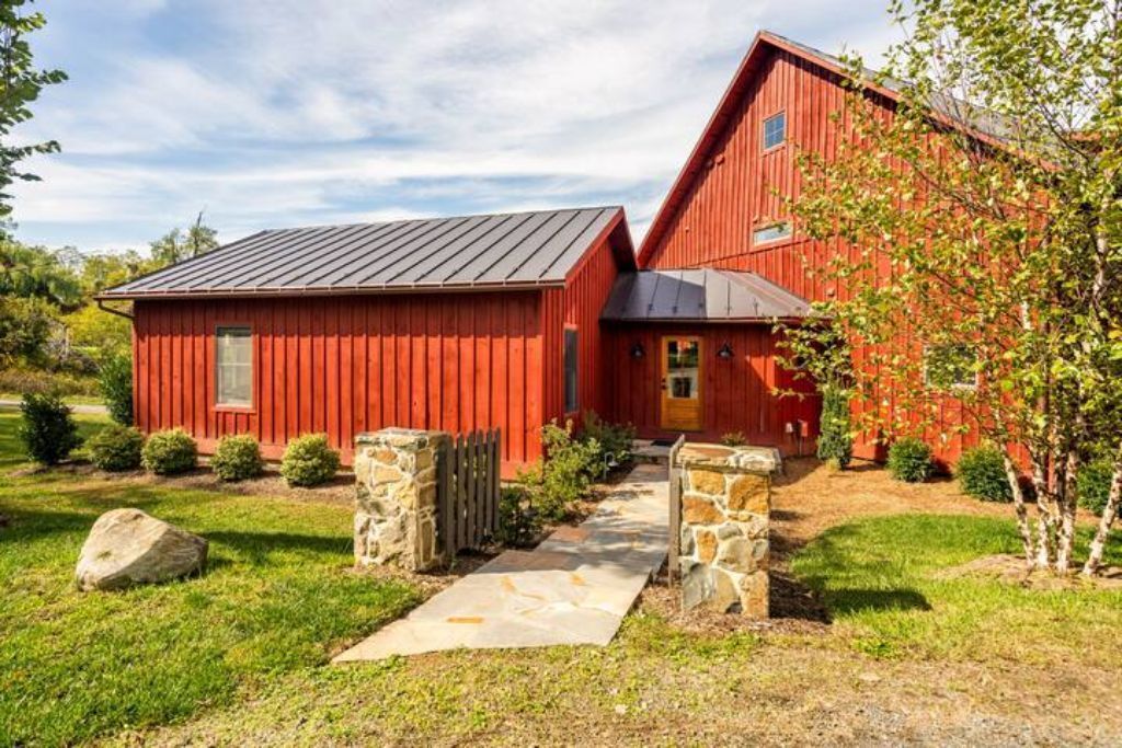 A red barn-style house with a stone pathway leading to the front door.