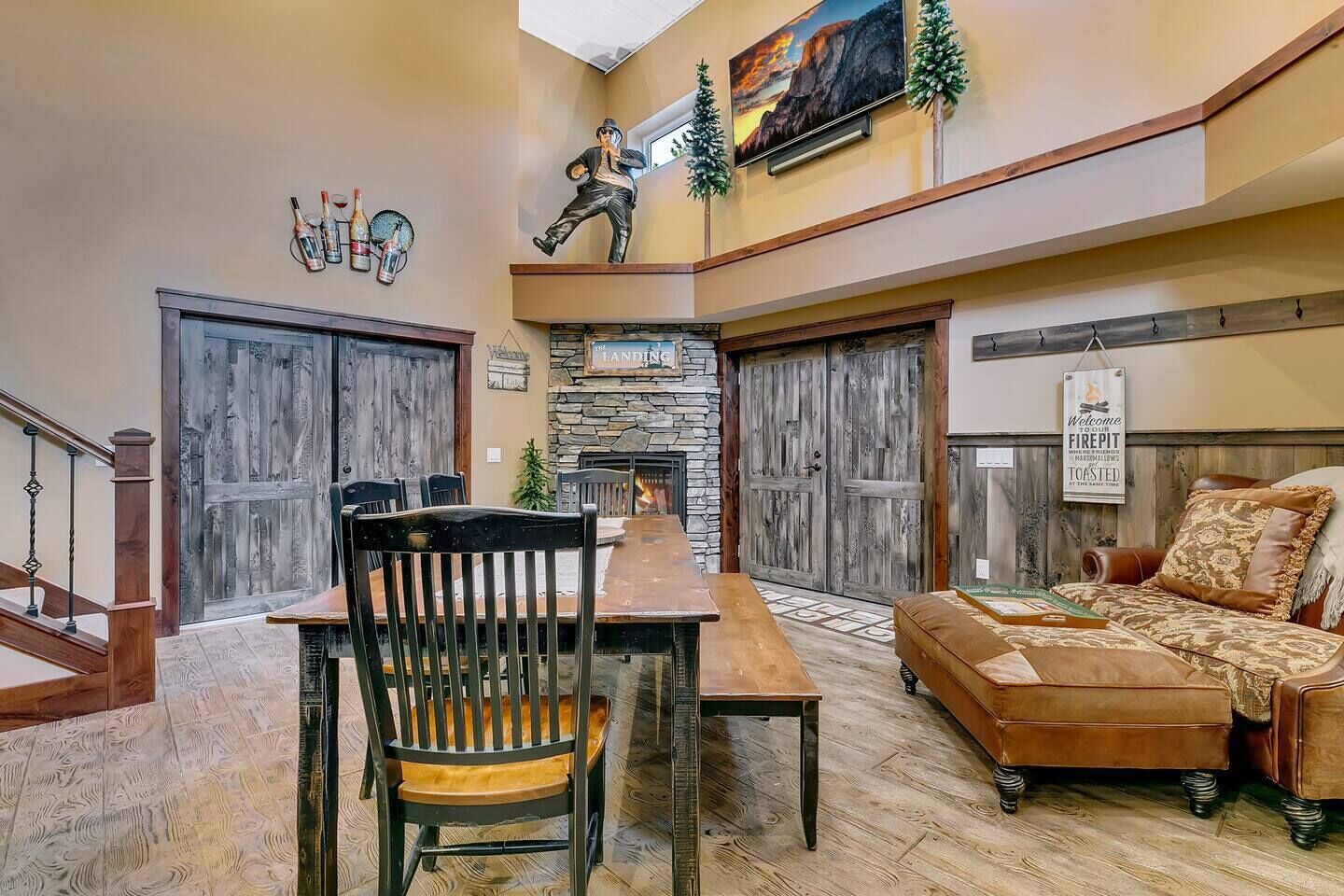 A spacious living area with a wooden dining table, a comfortable sofa, and a stone fireplace.
