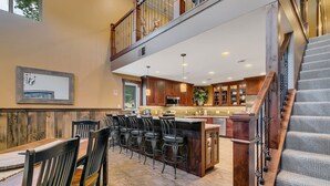 A spacious kitchen with a high ceiling, wooden cabinets, and a central island with bar stools. - Great outdoor entertainment with slip on Cross Lake (Crosslake)