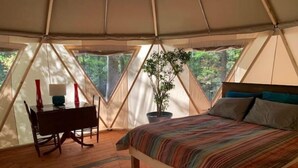 A tent with a bed, a desk, and a chair. - Plush Yome Tucked in the Woods (Monticello)