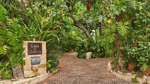 A cobblestone pathway leading to a sign labeled "Casa Charcos." - Casa Los Charcos
 (Playa del Carmen)