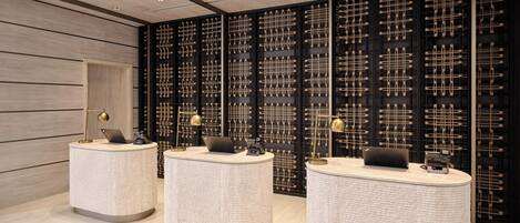 A reception area with three round, textured counters and a black wall with a woven pattern.