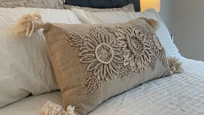 A bedroom with a tufted headboard, a large painting on the wall, and a bedside lamp. - Full Comfy&Private Suite with a Yard for Your Getaway in Bear Mountain, Victoria (Victoria)