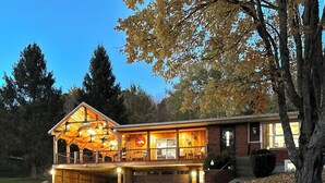 A lodge with a large porch, a garage, and a covered outdoor seating area.