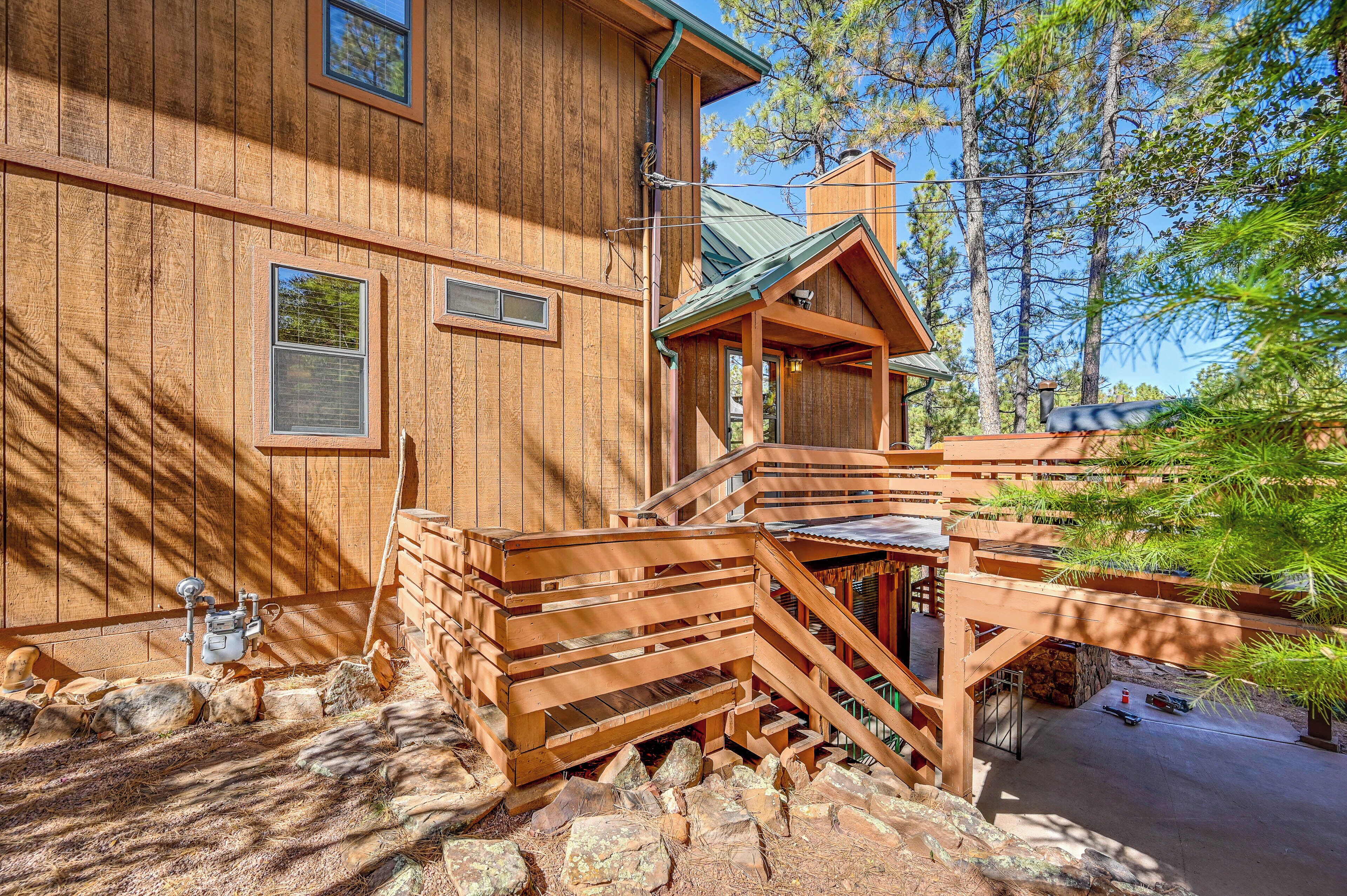 A wooden cabin with a wooden staircase leading to a porch.